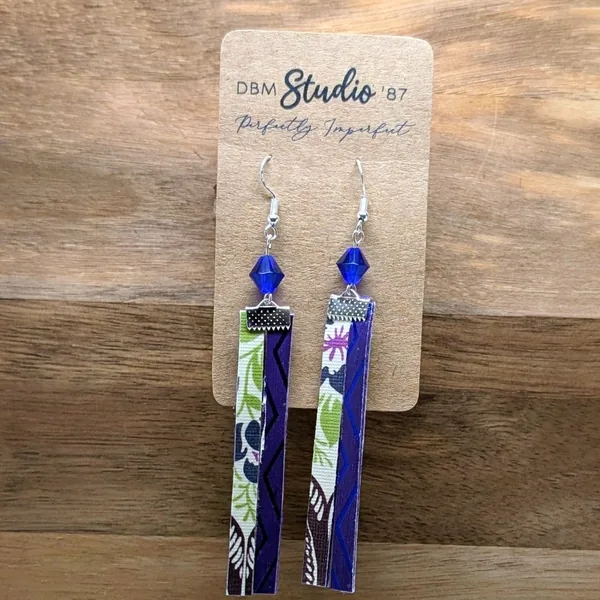 Earrings with green, pink, purple florals and blue-purple swirls with a blue bead and silver findings.